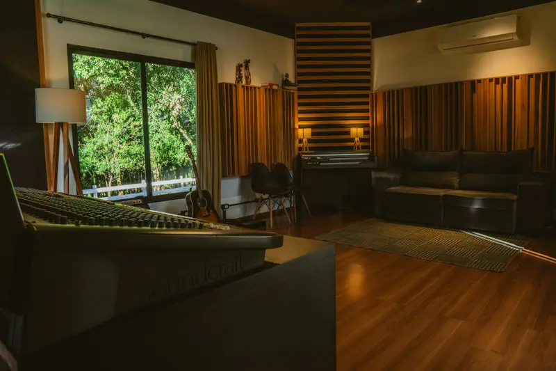 Sala de control de un estudio de grabación con consola y ventanal